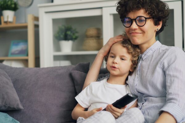 a woman sitting on a couch next to a little girl