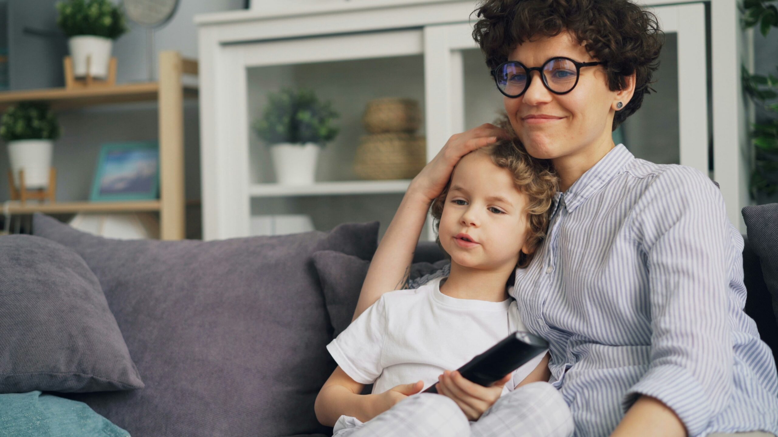 a woman sitting on a couch next to a little girl