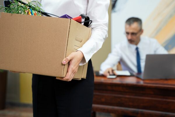 Woman carrying cardboard box side view