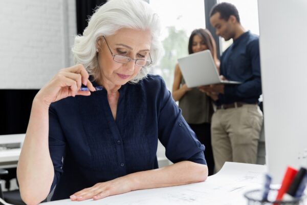 Mature businesswoman working with documents while sitting at her workplace