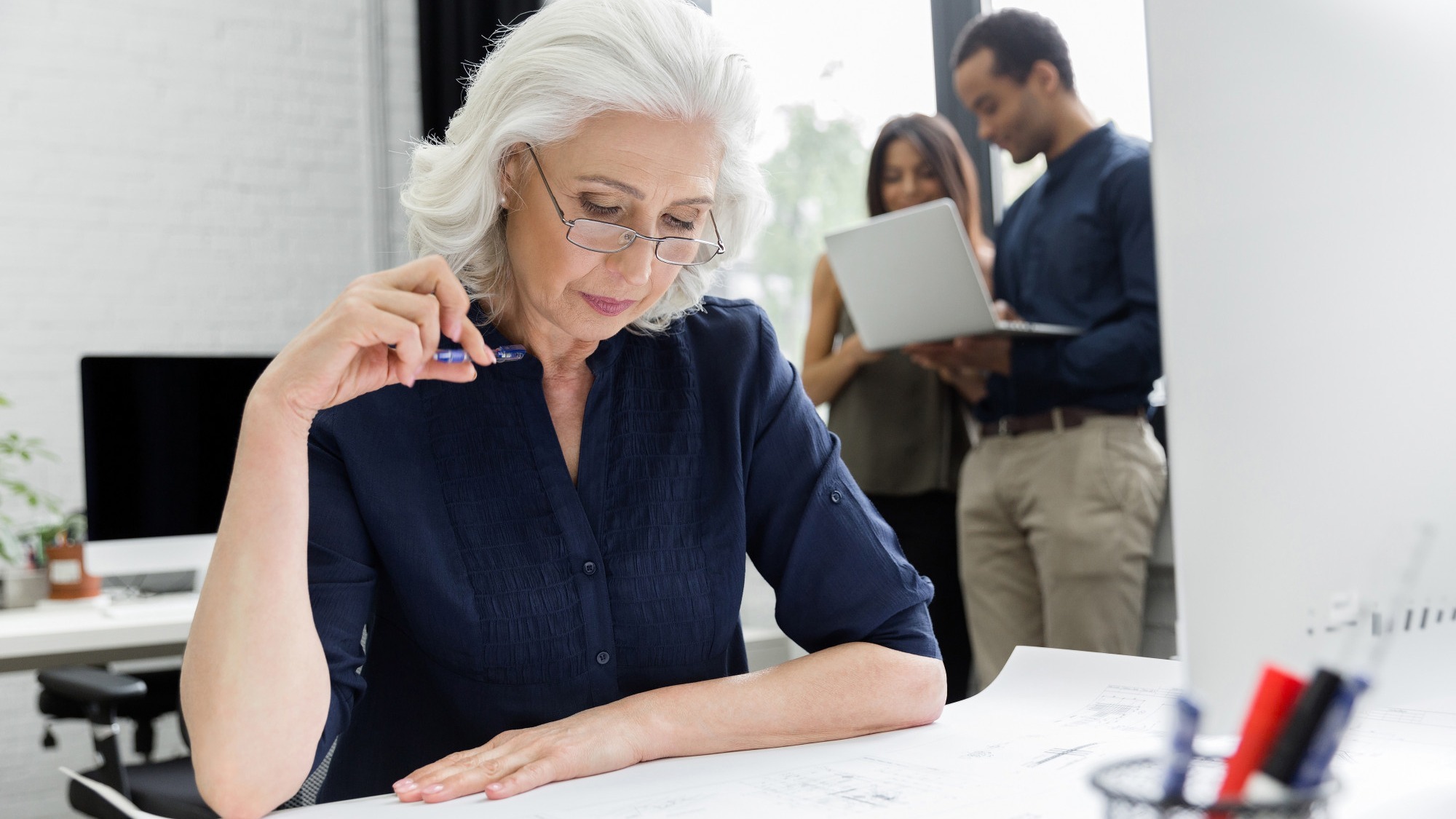 Mature businesswoman working with documents while sitting at her workplace