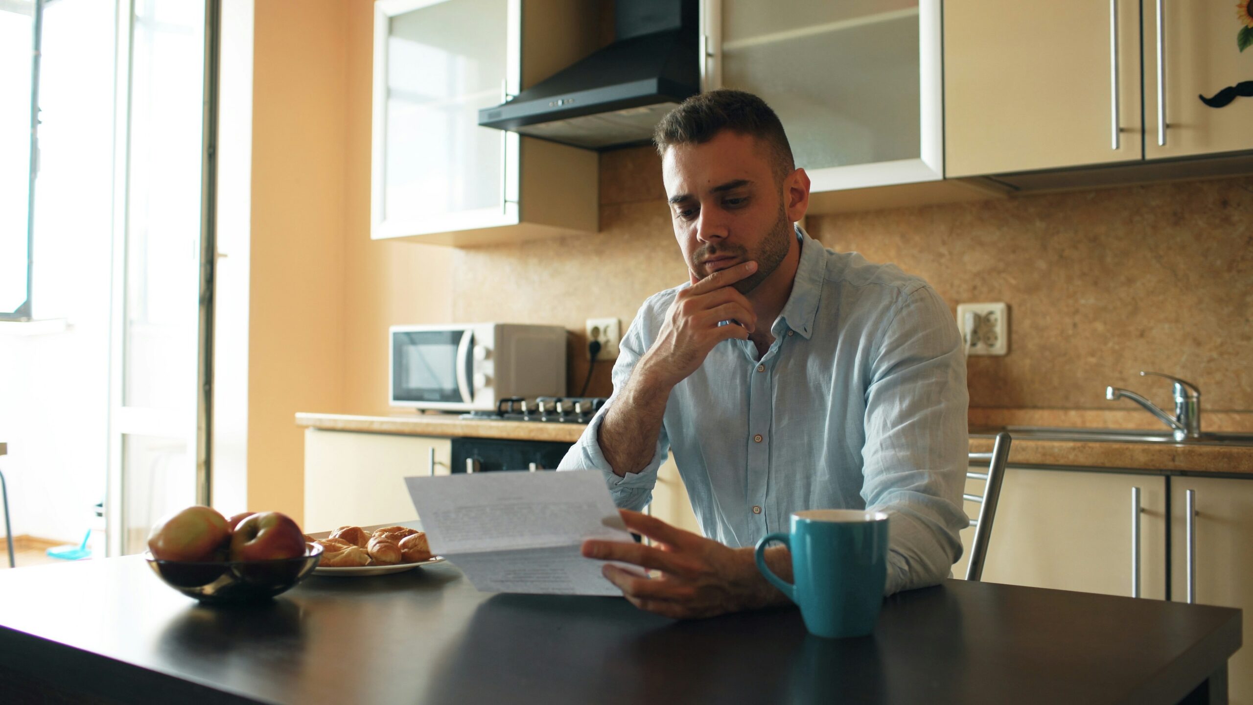 Man reading a document in a kitchen