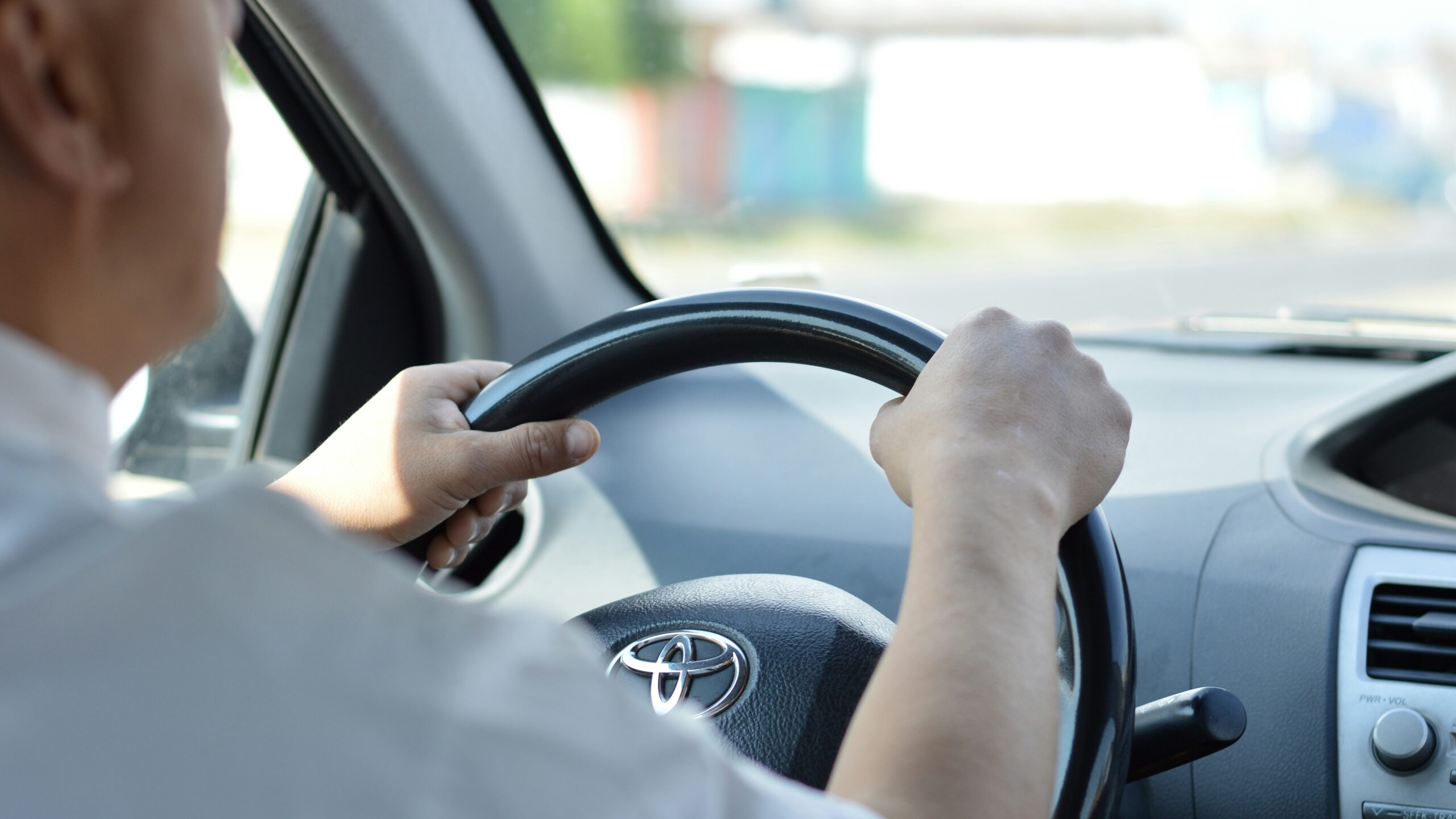 person in white long sleeve shirt driving car