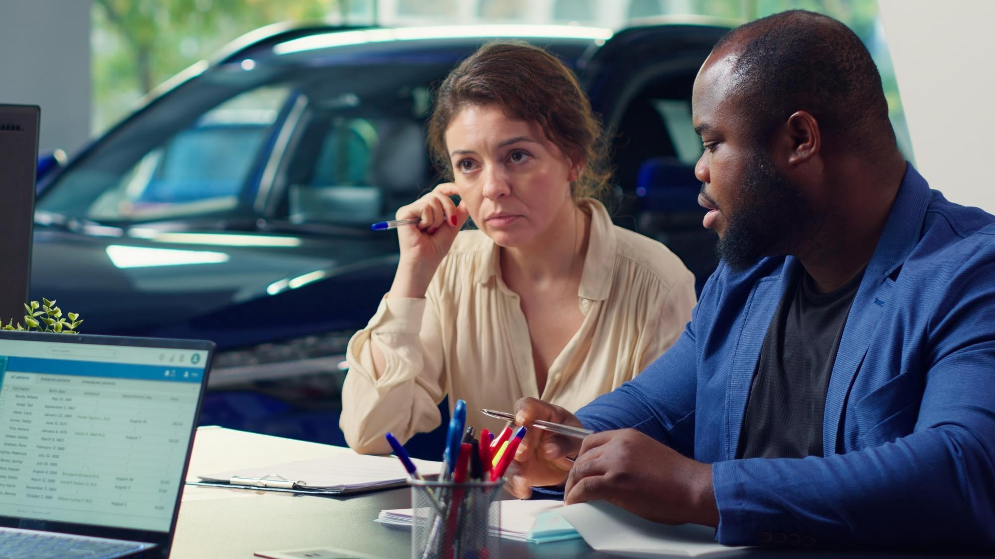Customers in dealership completing necessary car payment paperwork