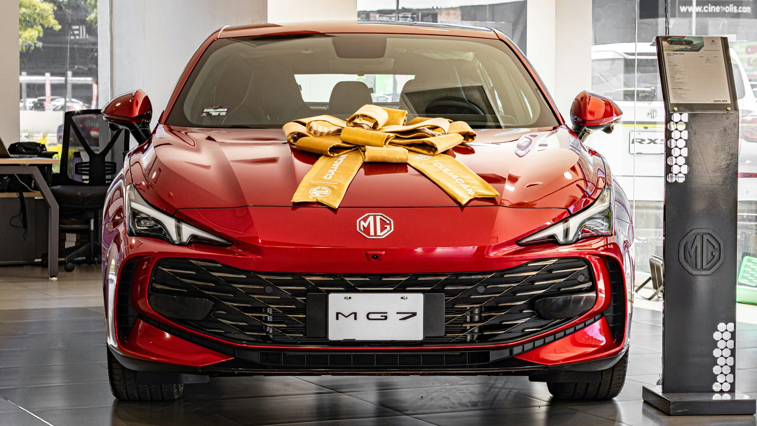 Red mg 7 car decorated with a large gold bow.