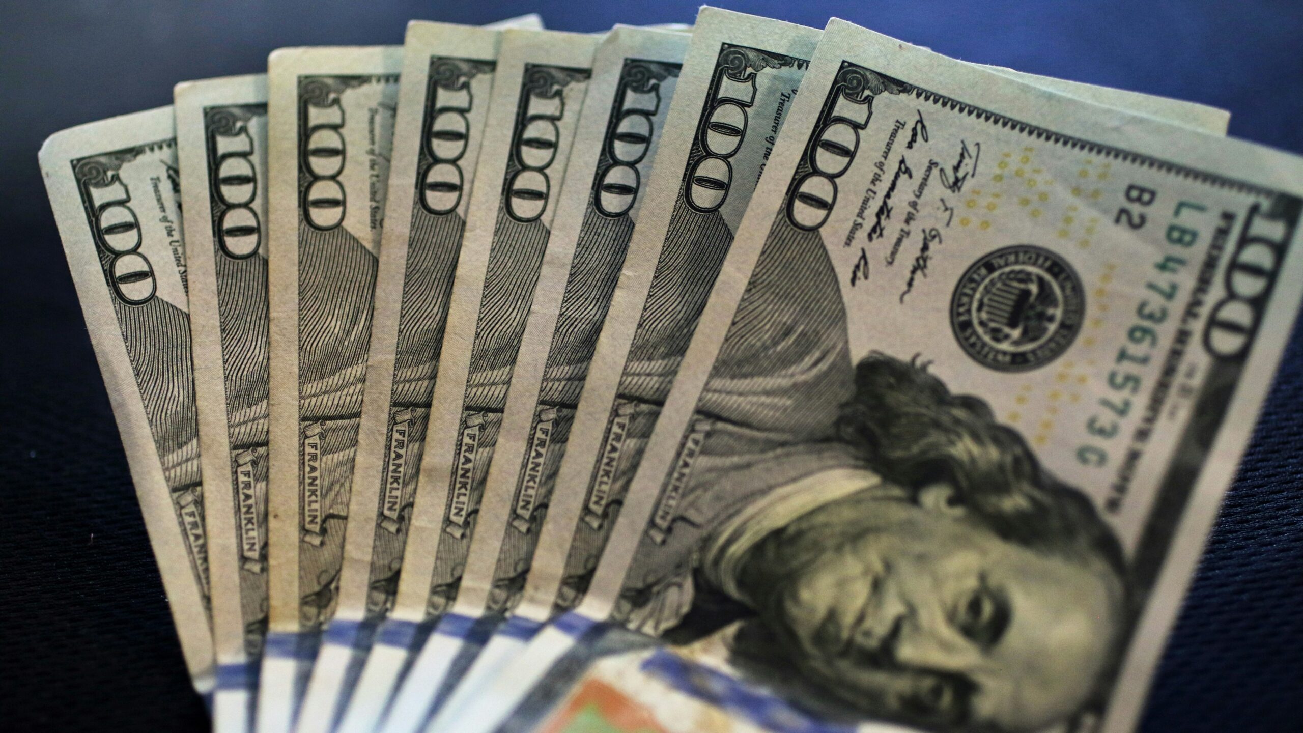 a stack of twenty dollar bills sitting on top of a table
