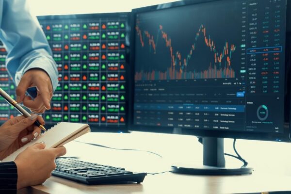 A cropped closeup image of professional smart trader hand pointing at financial growth graph while write data analysis in notebook Business finance and Stock market investment concept Burgeoning