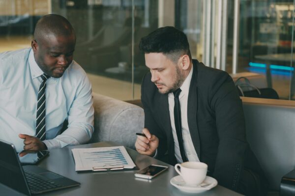 Two businessmen reviewing documents at a table.