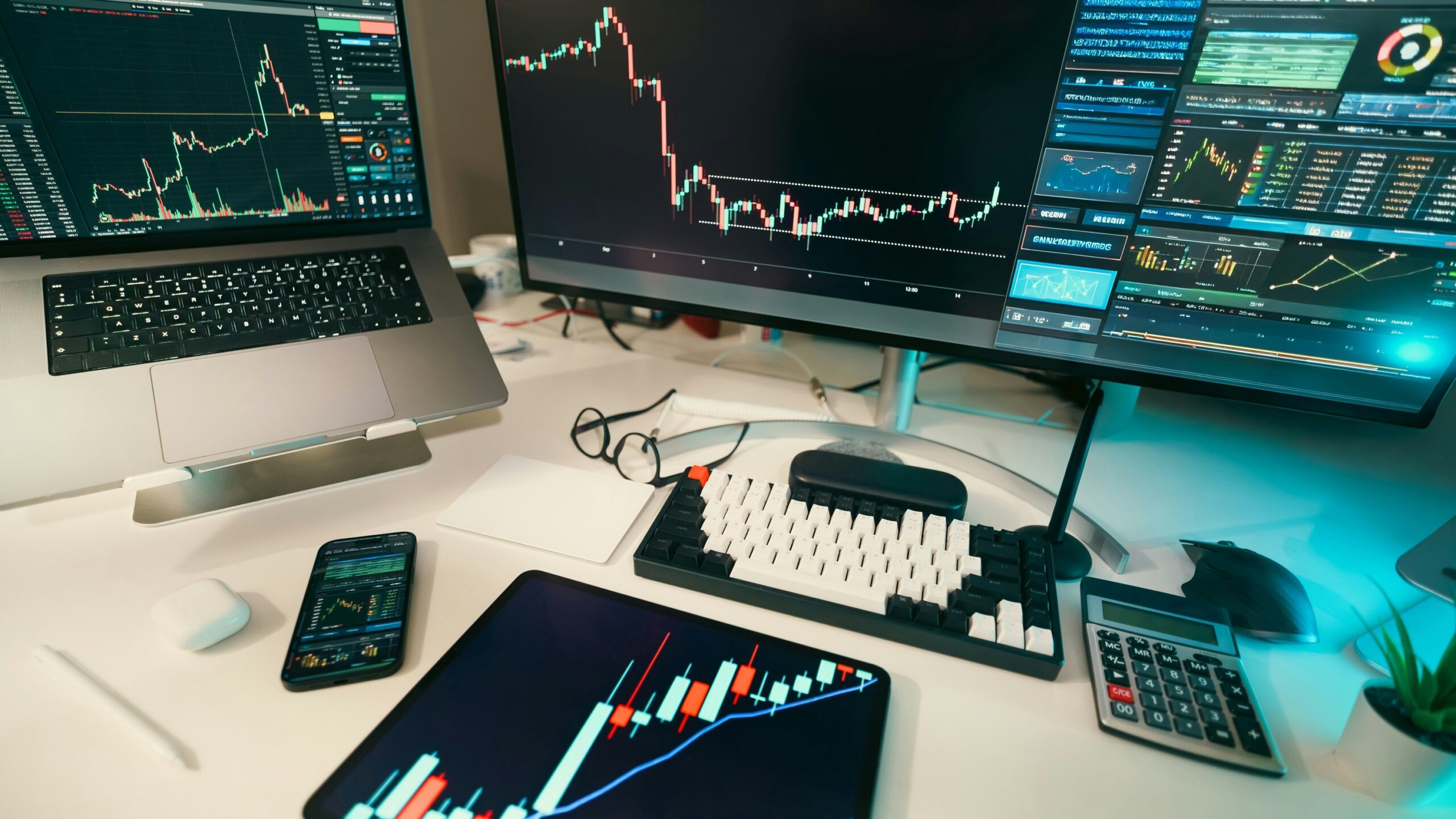 Stock charts are displayed on multiple screens.