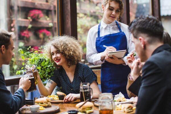 Waitress taking orders from people in restaurant