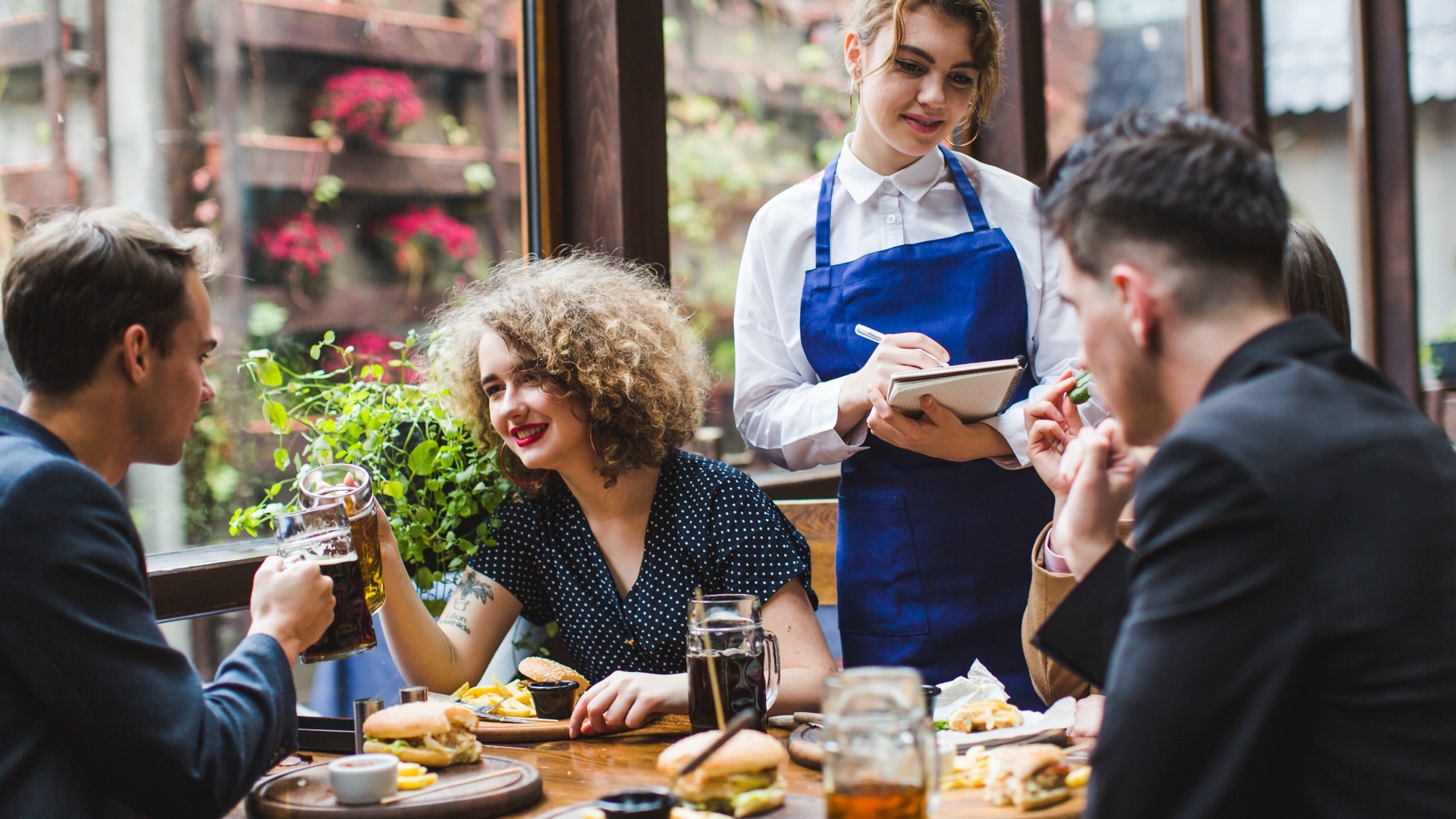 Waitress taking orders from people in restaurant