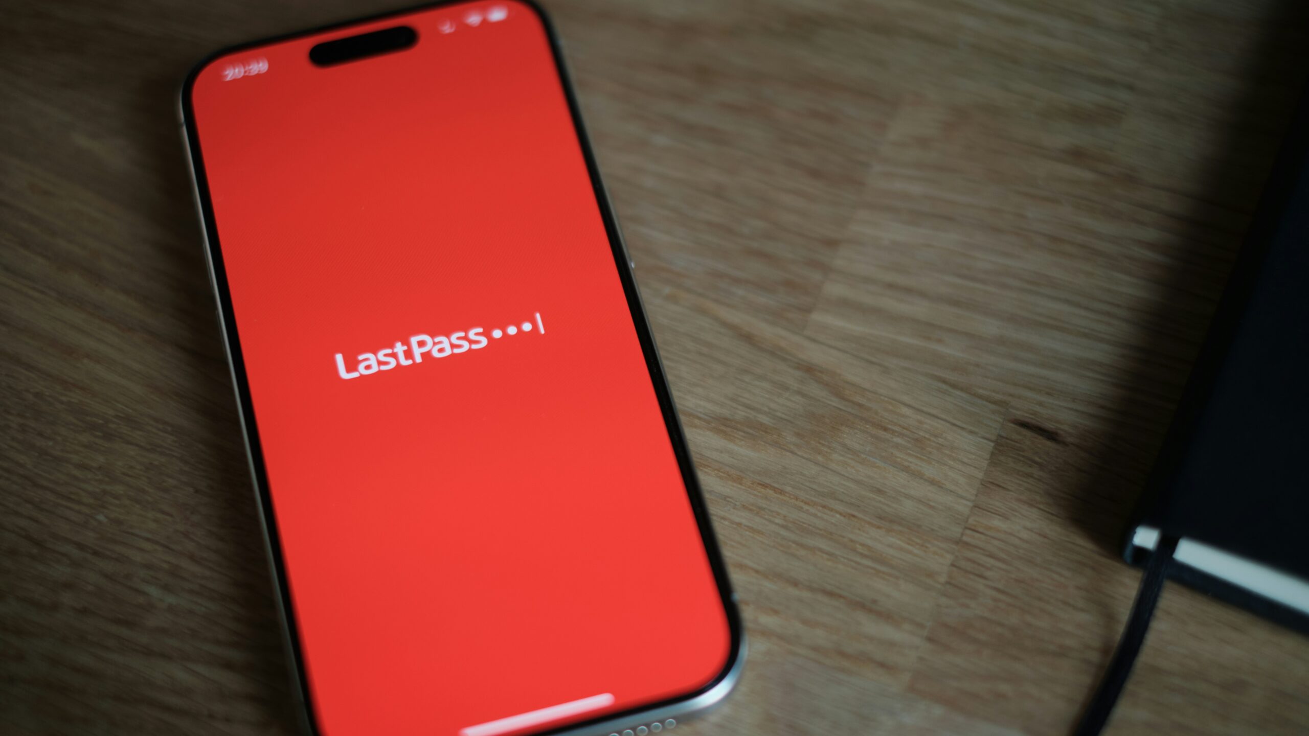 A red cell phone sitting on top of a wooden table