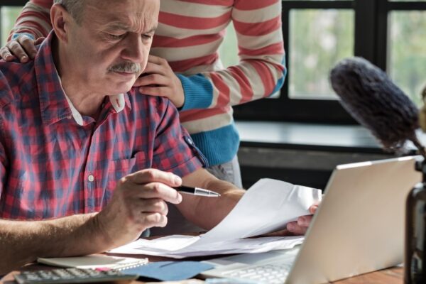 Serious mature hispanic man man checking home finance calculating money