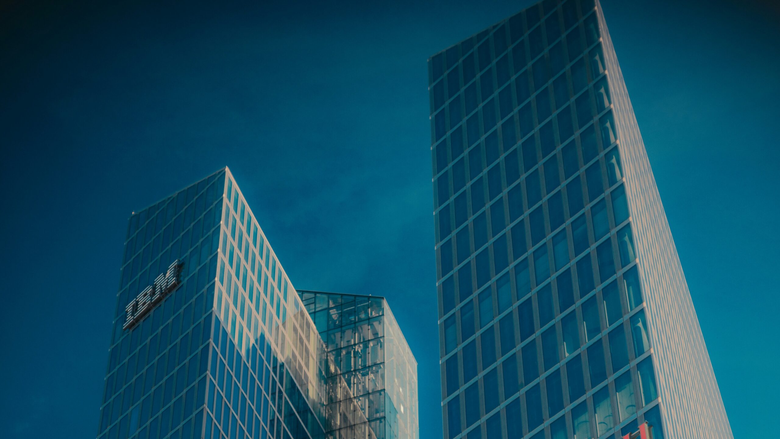 Modern glass skyscrapers with ibm and fujitsu logos.