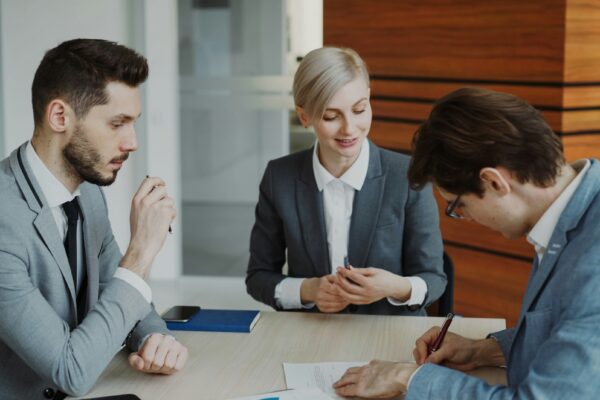 Business people signing a contract at a table.