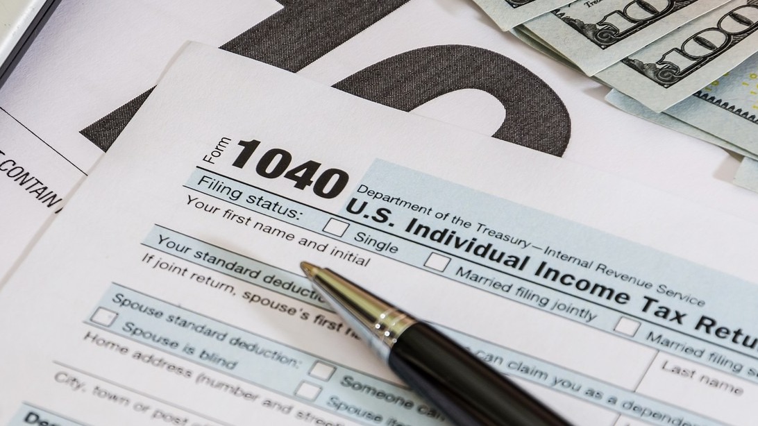 tax forms 1040 and calculator with dollars