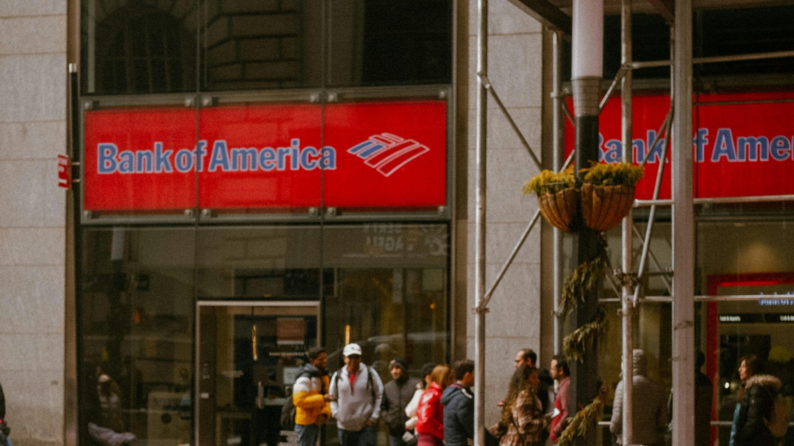 a red sports car is parked in front of a bank of america