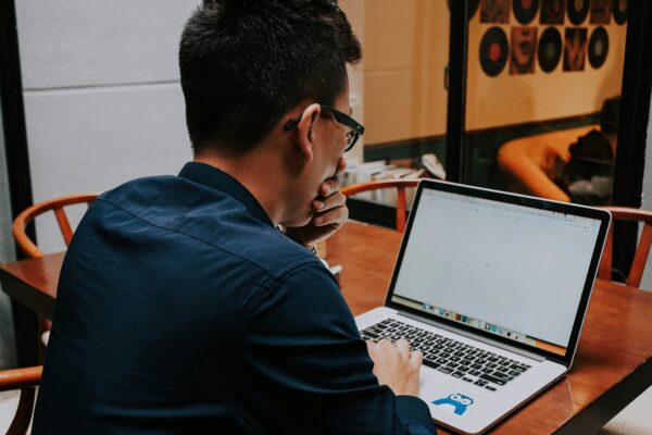 a man sitting at a table using a laptop computer