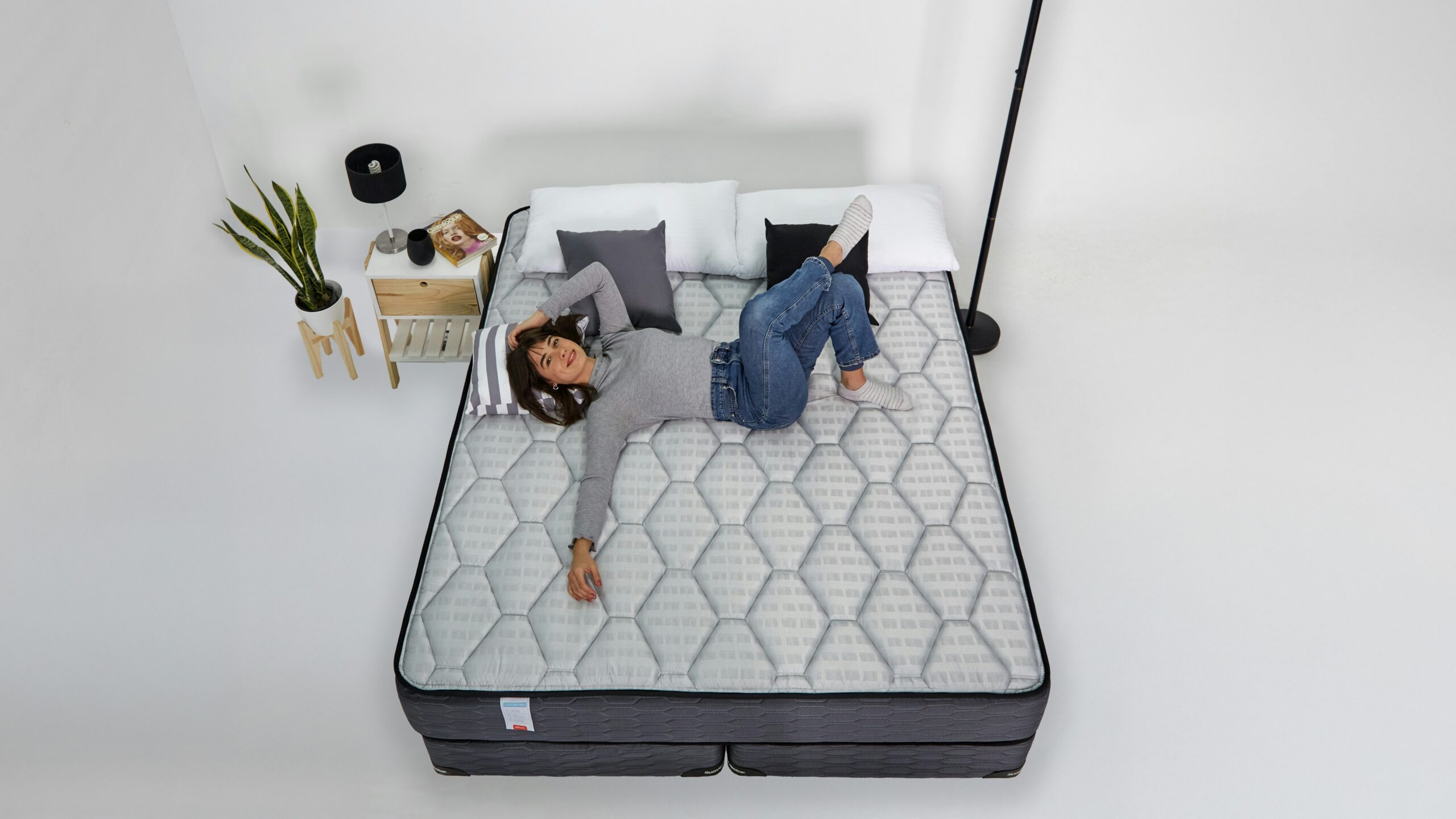 Woman relaxing on a mattress with headphones on.
