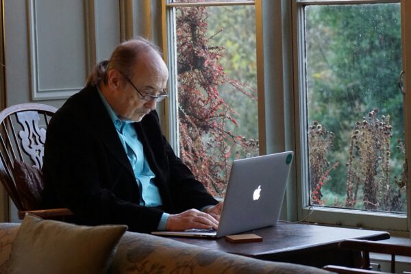 man in black suit jacket using macbook