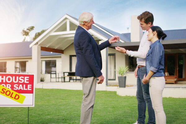 Couple real estate and realtor with keys to new home payment or mortgage loan on lawn outside Happy man and woman in relationship or homeowners with agent for buying property sale or sold house