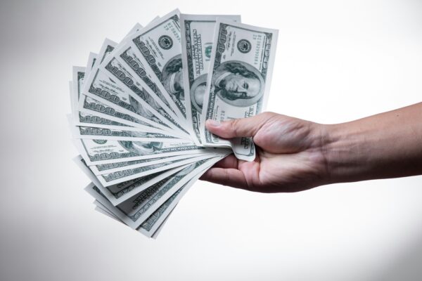 person holding 100 US Dollar banknote