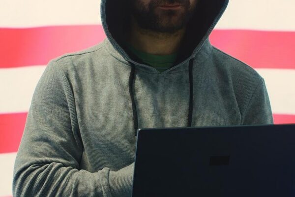 A hacker working in a governmental IT workspace with the USA flag