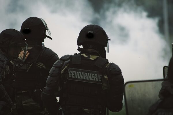 2 men in black police uniform standing on road during daytime