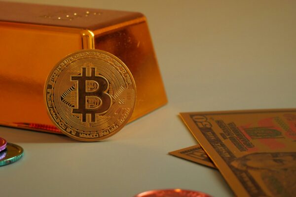 Bitcoin coin with gold bar and currency notes.