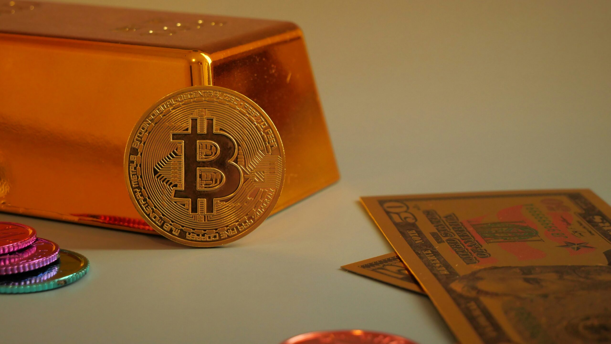 Bitcoin coin with gold bar and currency notes.