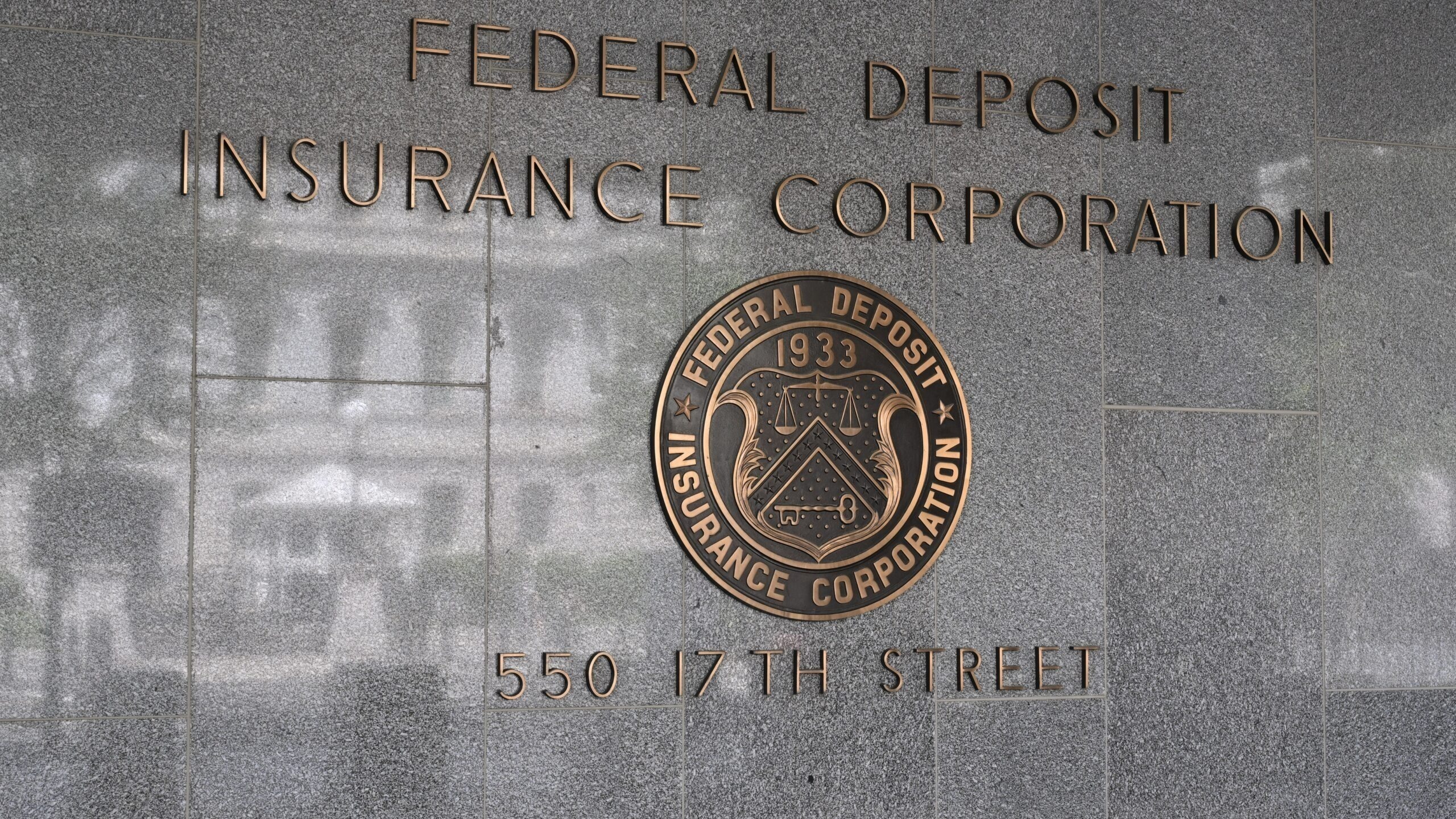 The sign for the Federal Deposit Insurance Corporation mounted on the exterior wall of a building. 550 17th Street NW, Washington, DC 20429.