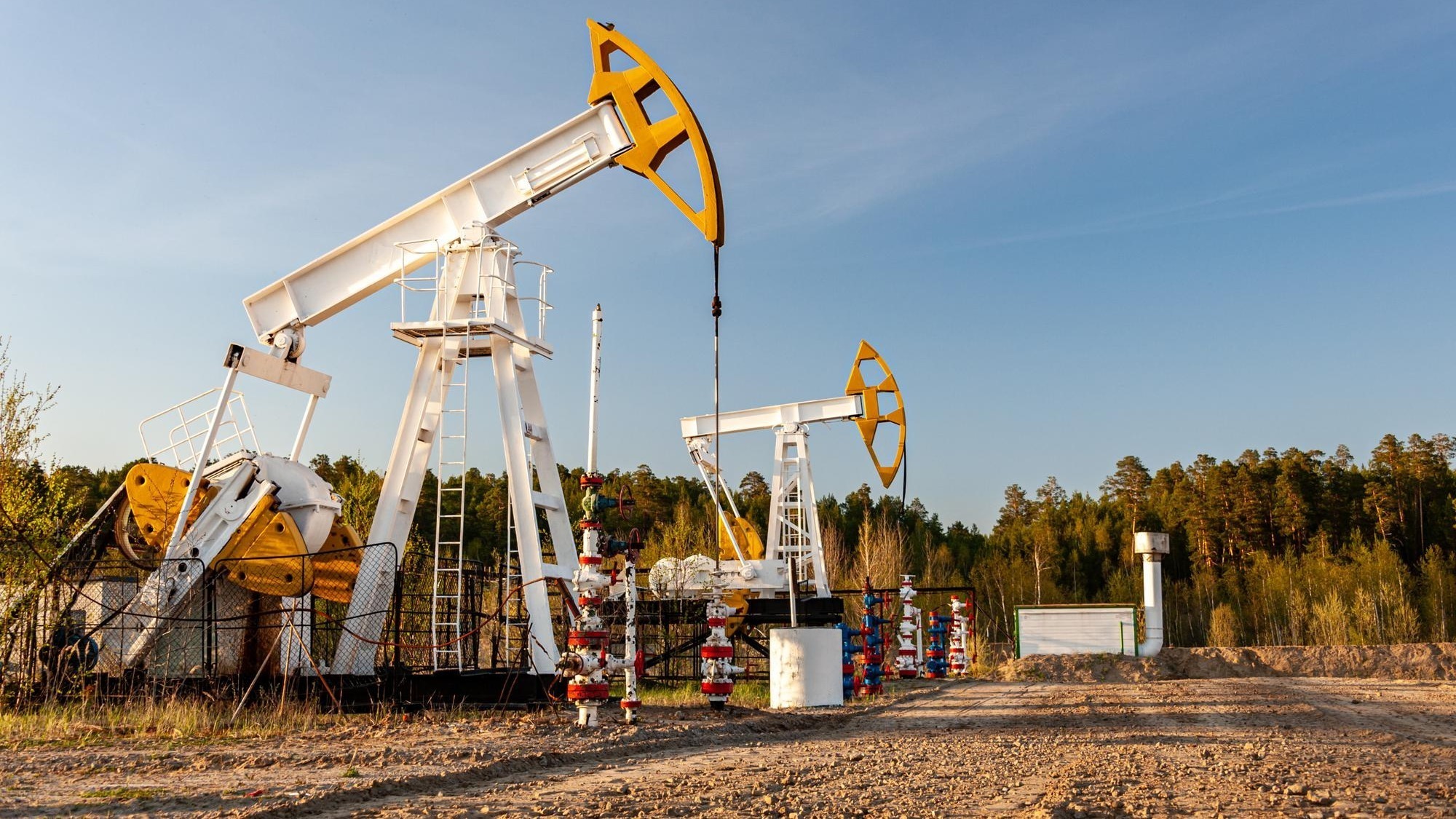 Oil pump rig. Oil and gas production. Oilfield site. Pump Jack are running. Drilling derricks for fossil fuels output and crude oil production. War on oil prices. Global coronavirus COVID 19 crisis.