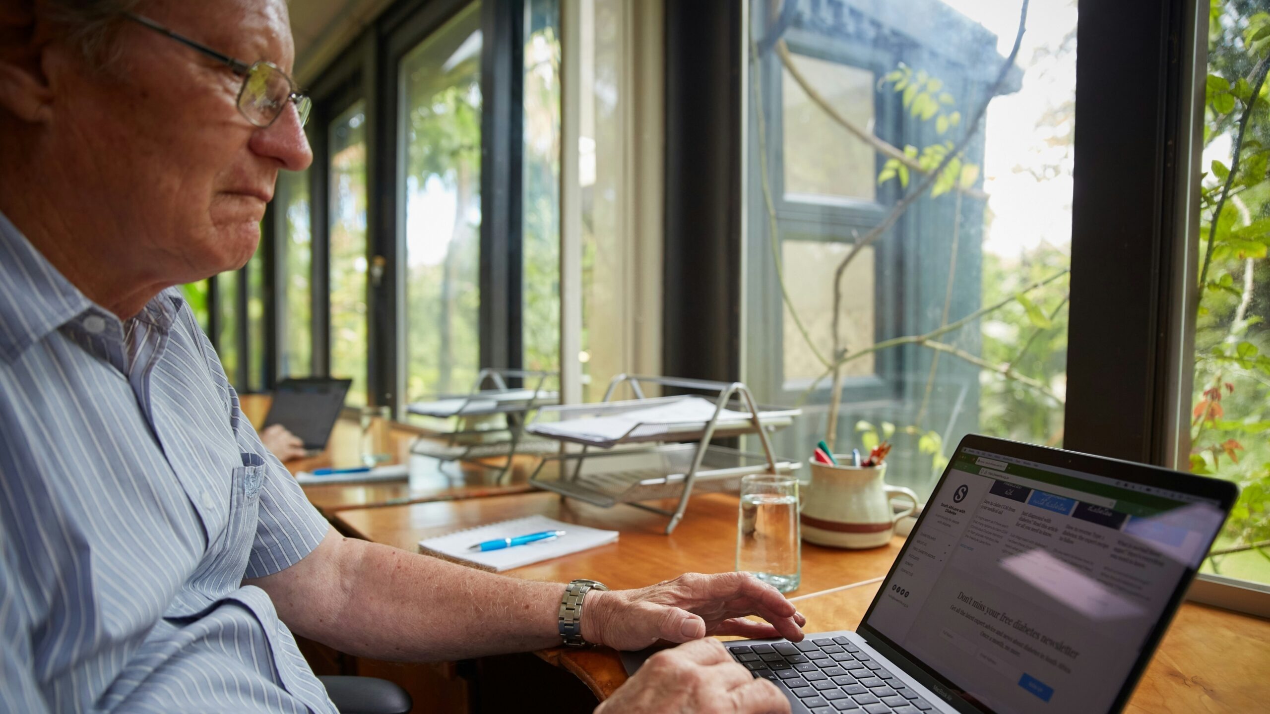 a man sitting at a table using a laptop computer