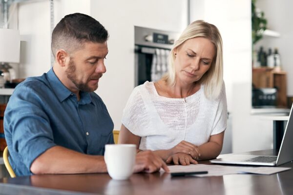 Cropped shot of young couple going through paperwork while doing their budget at home