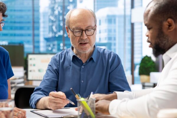 Mature person signing a contract with insurance agency banker
