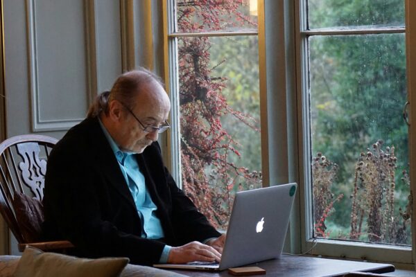 man in black suit jacket using macbook