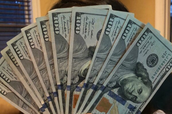 person holding fan of us dollar bill