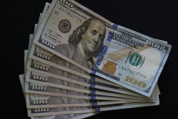 a stack of twenty dollar bills on a black background