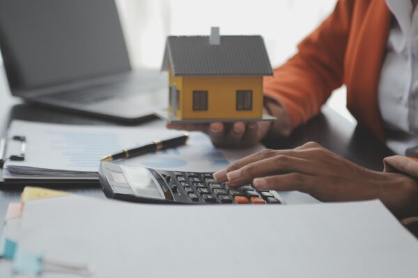 Female woman hands holding home model small miniature white toy house Mortgage property insurance dream moving home and real estate concept