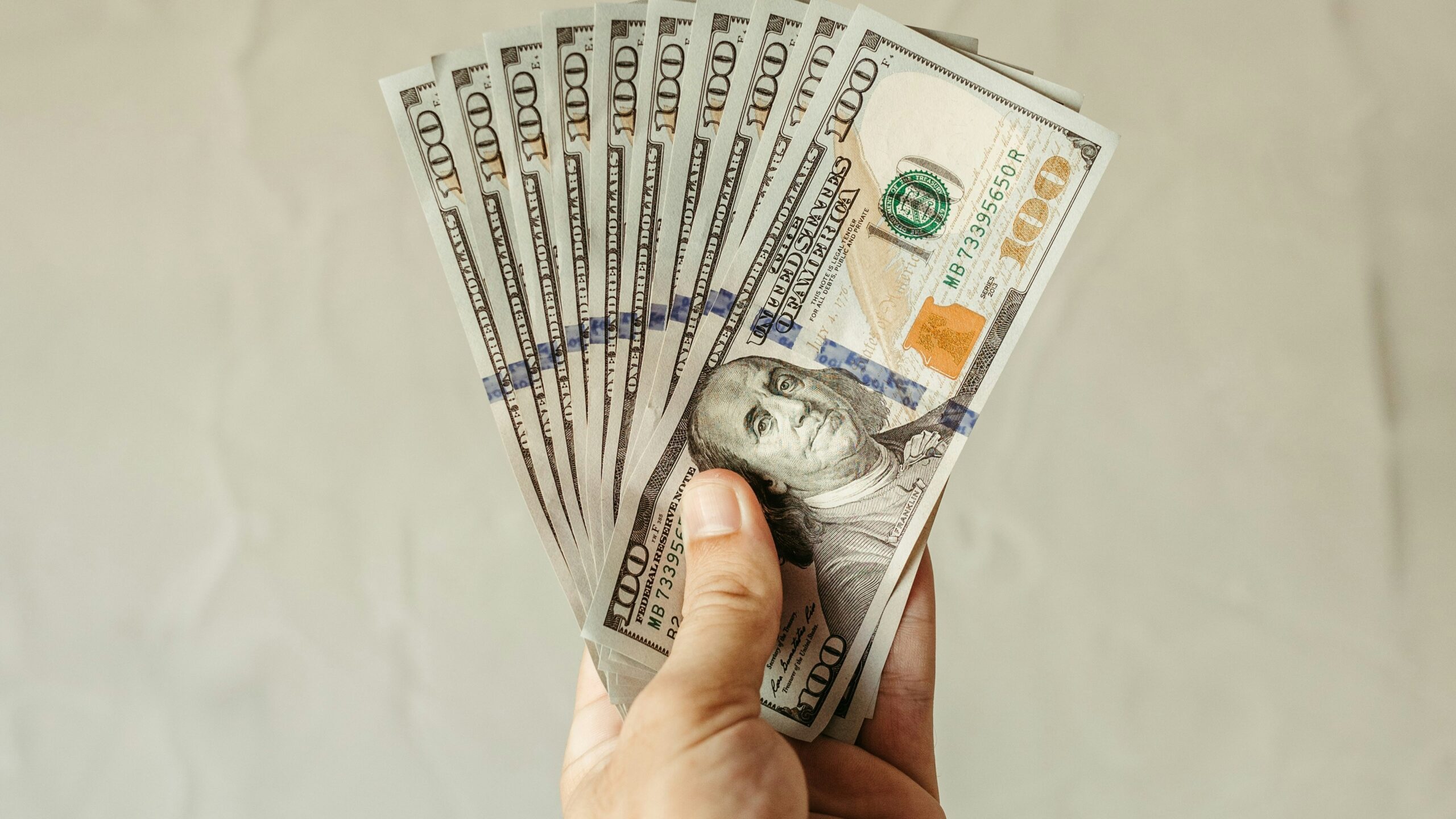 a person holding a bunch of money in their hand