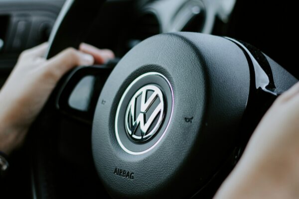 person holding black Volkswagen steering wheel in closed-up photo