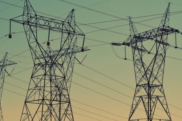 black transmission towers under green sky