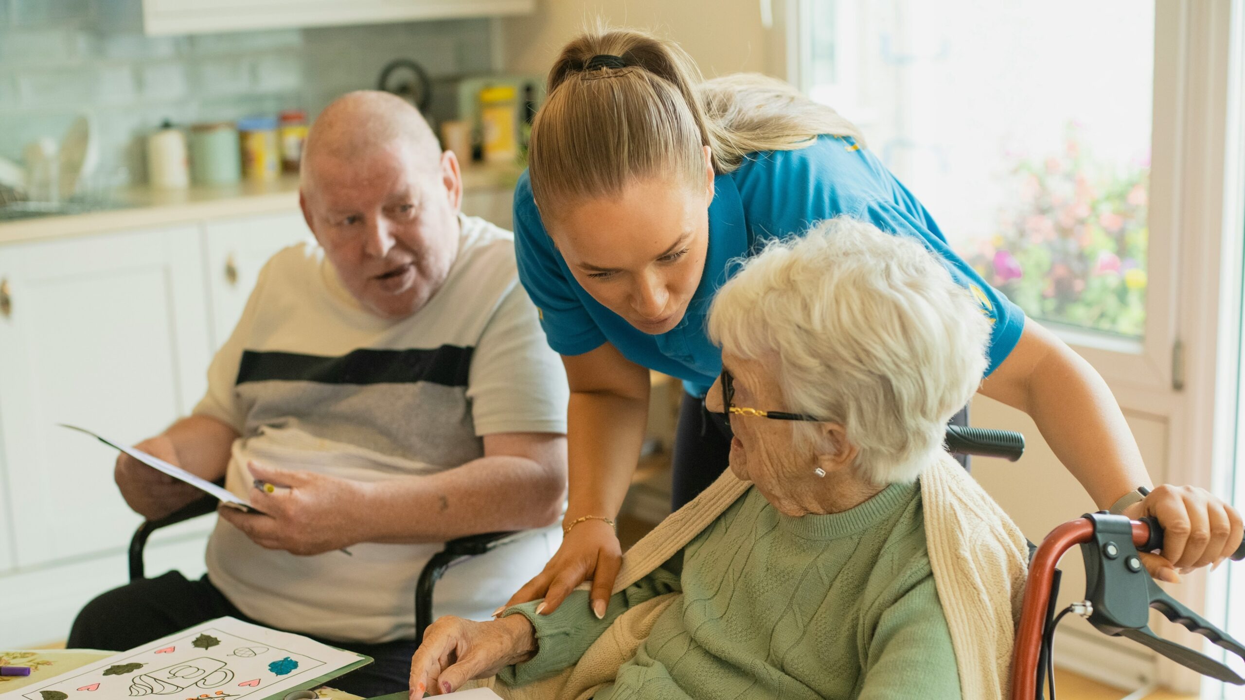 Caregiver assisting elderly couple with coloring