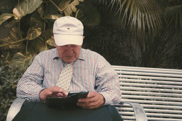 a man sitting on a bench looking at his cell phone