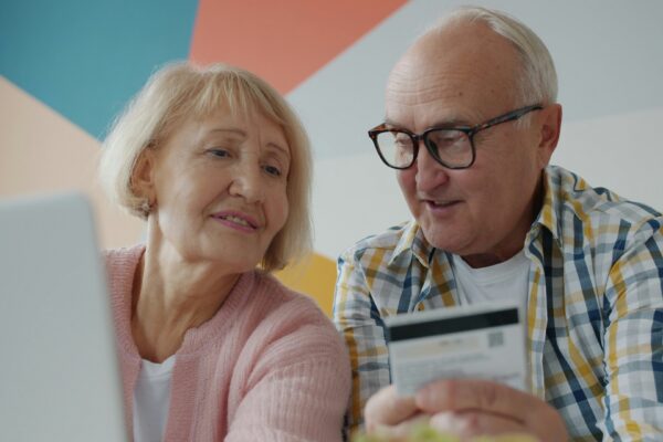 Elderly couple looking at laptop with credit card