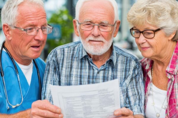 Medical worker showing document to senior couple