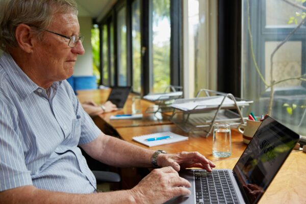 a man sitting at a table using a laptop computer