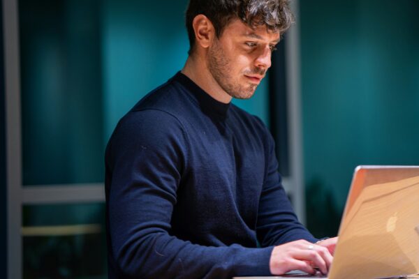 man in black long sleeve shirt using macbook