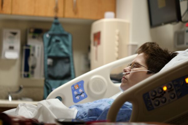 boy lying on beige recliner hospital bed