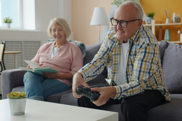 Elderly couple playing video games on the couch